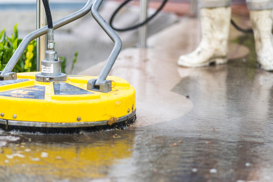 Professional concrete cleaning in progress with surface cleaner